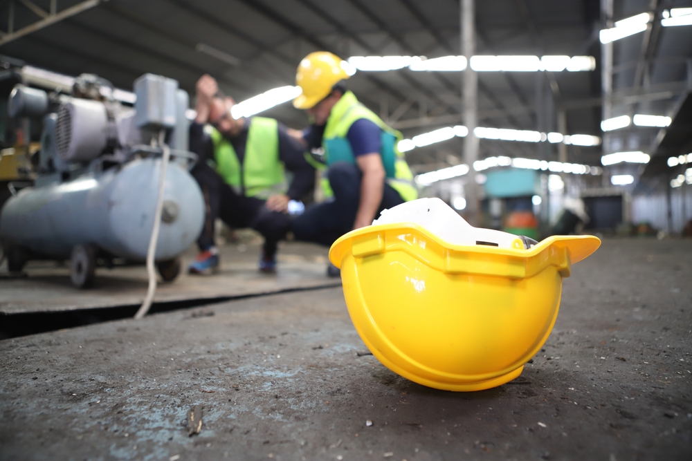 Injured construction worker on the ground after a workplace accident, highlighting risks that lead to shoulder injuries on job sites