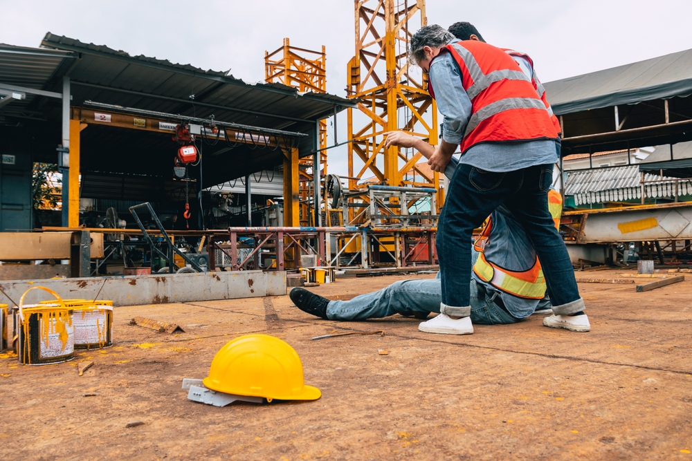 NYC construction worker assisting injured colleague after a job site accident
