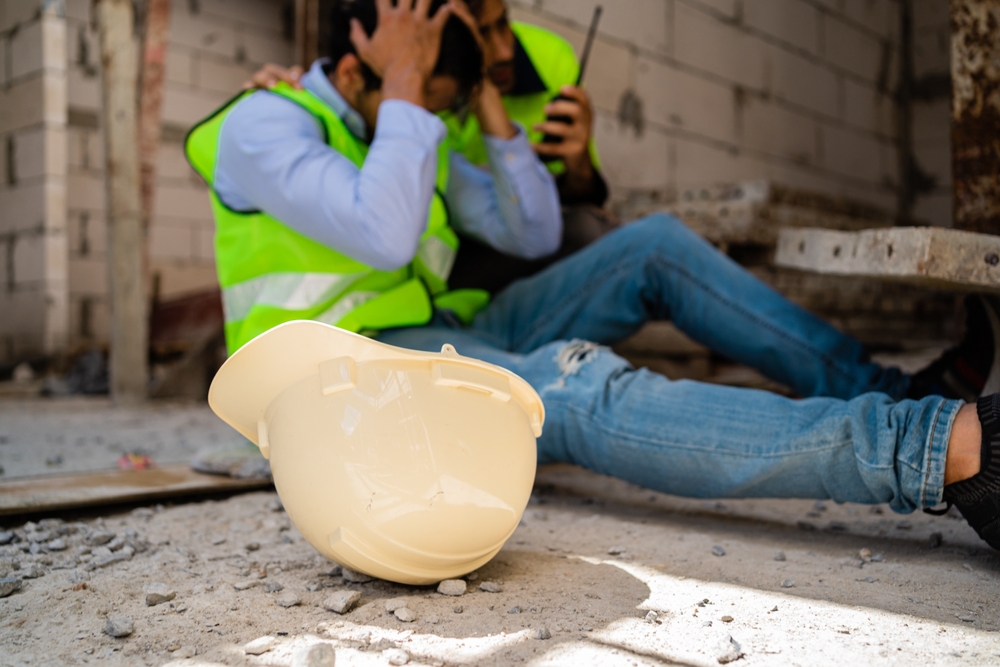 Construction worker sitting on the ground with a head injury after a job site accident in New York