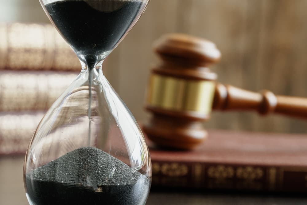 Hourglass and judge gavel on table close up