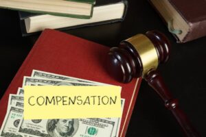 Gavel lying on the book and cash with a note of compensation