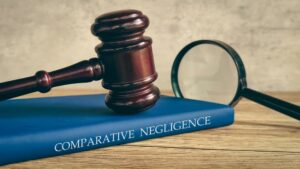 A gavel and magnifying glass on a book titled "COMPARATIVE NEGLIGENCE,"