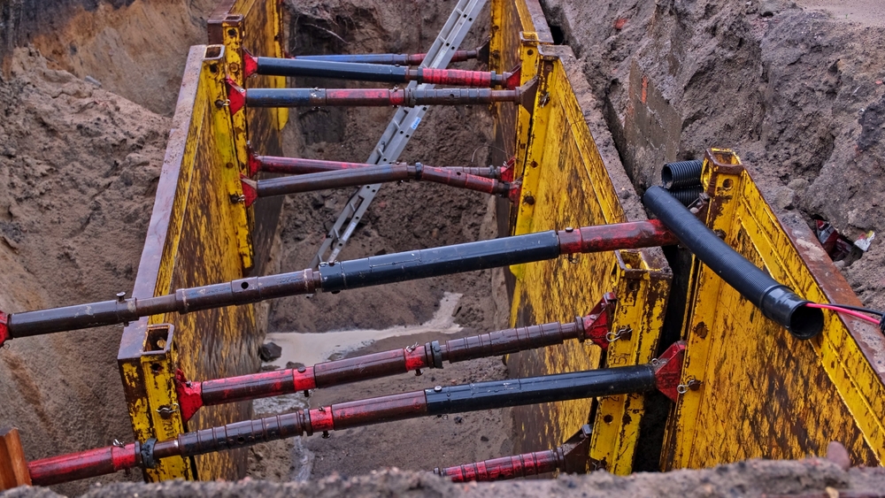 A trench in sandy soil supported by shoring bracers