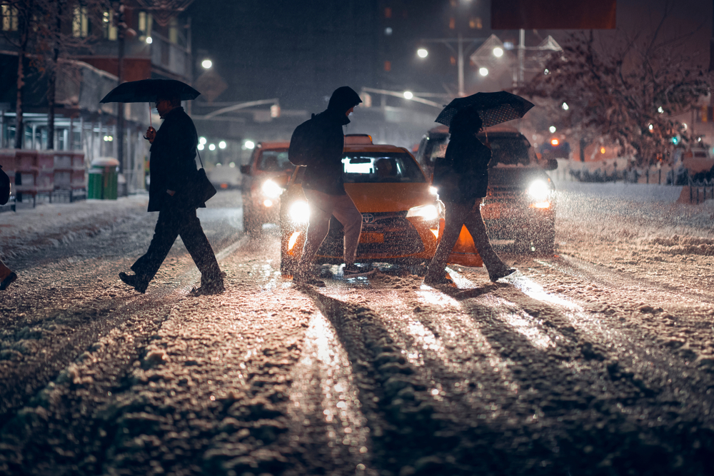 Pedestrians walking in snow, which can be tracked into a business, creating a slipping hazard