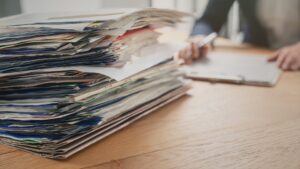 Lawyer at desk with stack of physical paper documentation